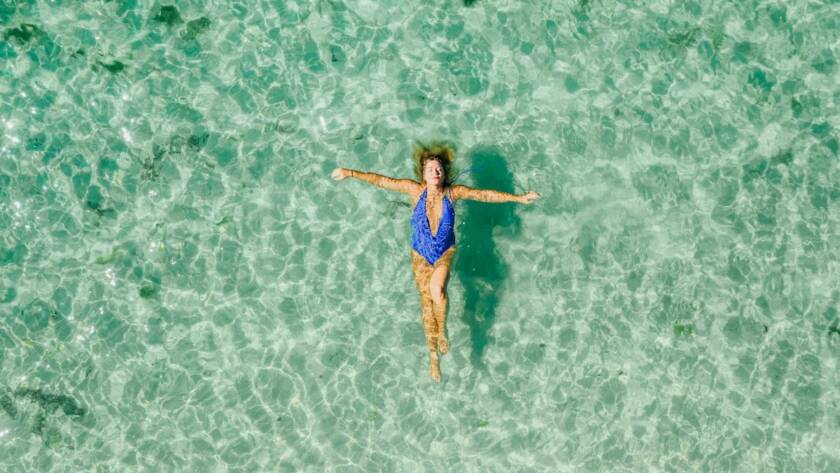mujer en la playa disfrutando del buen tiempo en bali