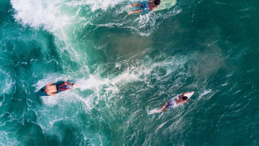 Personas haciendo surf en una playa de Bali